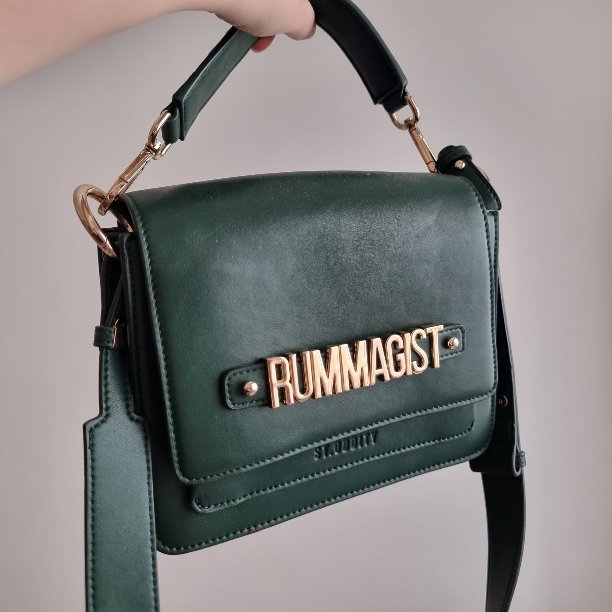 green handbag with gold letters spelling "rummagist".